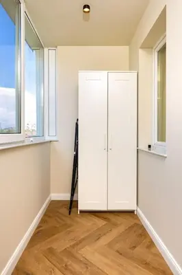a white cabinet in a room with two windows at Olive Green Designer Apartment in Plovdiv