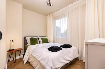 a bedroom with a bed with two black towels on it at Olive Green Designer Apartment in Plovdiv