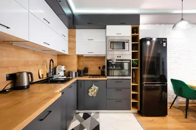 a kitchen with white cabinets and a black refrigerator at Feel Right at Home - Bright and Modern Apartment by Flat Mаnager in Sofia