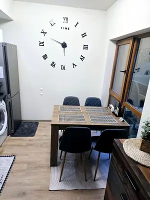 a dining room with a large clock on the wall at Apartment with veranda in Bansko