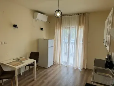 a small kitchen with a table and a refrigerator at Simple and Affordable Apartment in Bansko with available parking space in Bansko