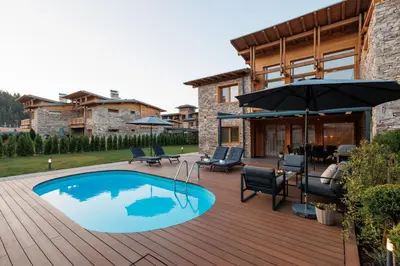 a patio with a swimming pool and an umbrella at Aqua Thermal Villa Banya in Banya
