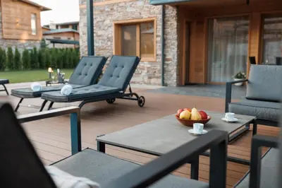 a patio with chairs and a bowl of fruit on a table at Aqua Thermal Villa Banya in Banya
