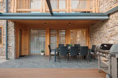 a patio with a table and chairs and a grill at Aqua Thermal Villa Banya in Banya