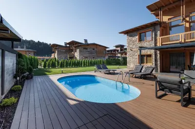 a swimming pool on a wooden deck with a house at Aqua Thermal Villa Banya in Banya