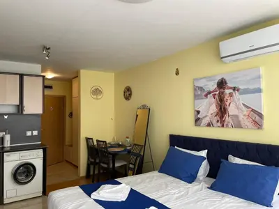 a room with a bed and a kitchen and a table at Blue Orchid Studio near airport & free parking in Sofia