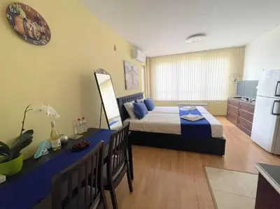 a bedroom with a bed and a table and a refrigerator at Blue Orchid Studio near airport & free parking in Sofia