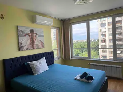 a bedroom with a blue bed and two windows at Blue Orchid Studio near airport & free parking in Sofia