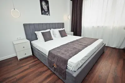 a bedroom with a large bed with a wooden floor at AGIA- luxury apartment Sofia in Sofia