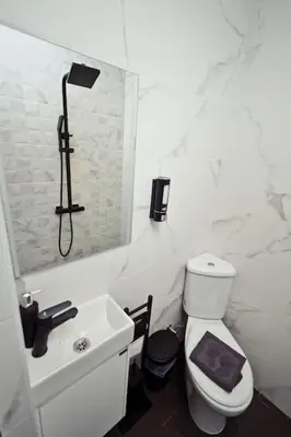 a white bathroom with a toilet and a sink at AGIA 2 - cozy one room apartment in Sofia