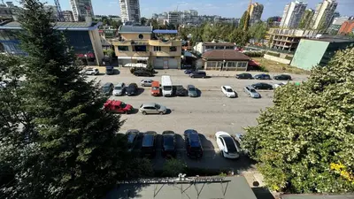 a parking lot with parked cars in a city at AGIA 2 - cozy one room apartment in Sofia