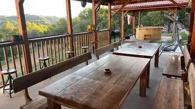 three wooden benches on a porch of a cabin at Вила Белият камък - Златоград in Zlatograd