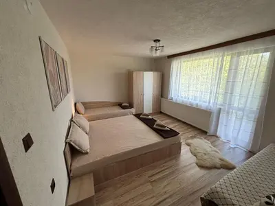 a bedroom with a bed and a large window at Вила Белият камък - Златоград in Zlatograd