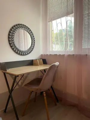 a desk with a chair and a mirror on a wall at Apartament-DEMIAN in Sofia