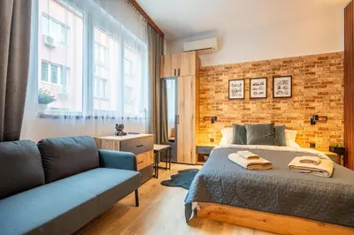a bedroom with a bed and a brick wall at BB Apartment in Sofia