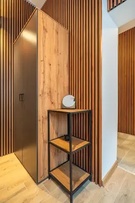 a shelf in a room with a wooden wall at BB Apartment in Sofia