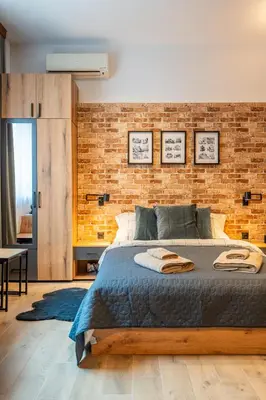 a bedroom with a brick wall and a bed at BB Apartment in Sofia