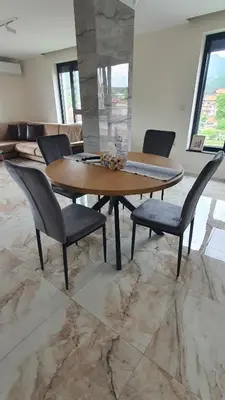 a dining room with a wooden table and chairs at Panorama view apartment in Gotse Delchev