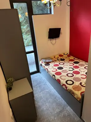 a small room with a bed and a window at Comfort Guest Rooms in Plovdiv