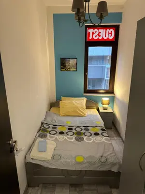 a small bedroom with a bed and a window at Comfort Guest Rooms in Plovdiv