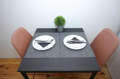 a black table with two plates and a plant on it at Уютна къща в сърцето на София in Sofia