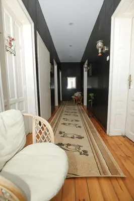 a hallway with a white couch and a rug at Уютна къща в сърцето на София in Sofia