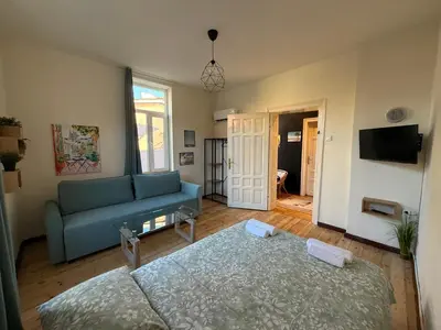 a living room with a blue couch and a table at Уютна къща в сърцето на София in Sofia