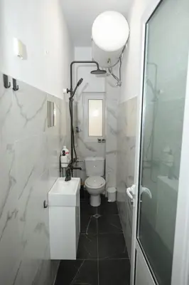 a white bathroom with a toilet and a sink at Уютна къща в сърцето на София in Sofia