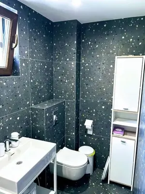 a bathroom with a toilet and a sink and a mirror at Къща за гости Алегра in Garmen