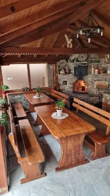 a dining room with wooden tables and a fireplace at Къща за гости Алегра in Garmen