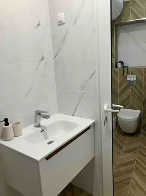 a white bathroom with a sink and a toilet at Apartament Aleksandar Premium in Kyustendil