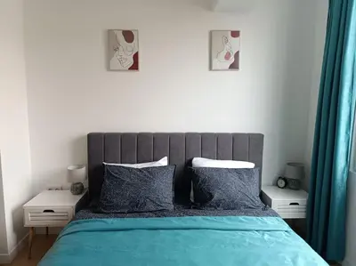 a bedroom with a bed with blue sheets and pillows at Apartament Aleksandar Premium in Kyustendil