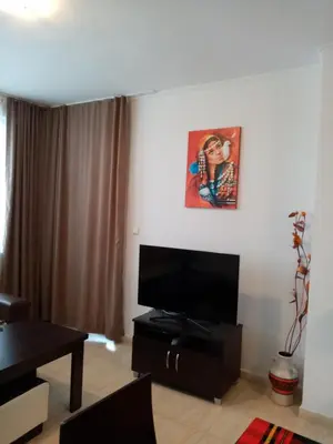 a living room with a television and a painting on the wall at Апартамент за гости 2Б14 Grand Monastiry in Pamporovo