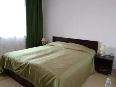 a bedroom with a bed with green sheets and a window at Апартамент за гости 2Б14 Grand Monastiry in Pamporovo