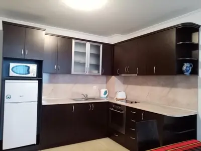 a kitchen with brown cabinets and a white appliance at Апартамент за гости 2Б14 Grand Monastiry in Pamporovo