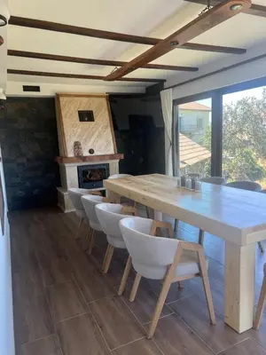 a dining room with a wooden table and chairs at ВИЛА ЯНА Villa Yana in Presoka