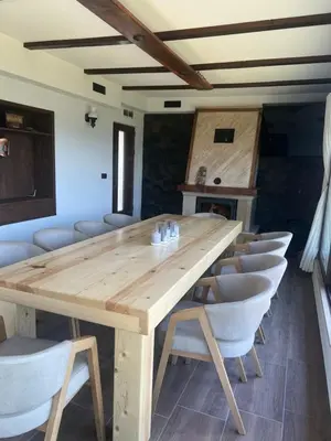 a wooden table and chairs in a room at ВИЛА ЯНА Villa Yana in Presoka