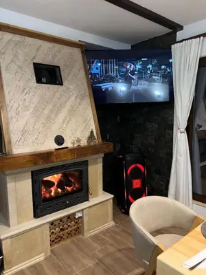 a living room with a fireplace and a tv at ВИЛА ЯНА Villa Yana in Presoka