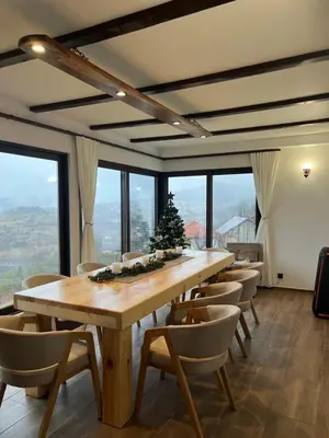 a dining room with a large wooden table and chairs at ВИЛА ЯНА Villa Yana in Presoka