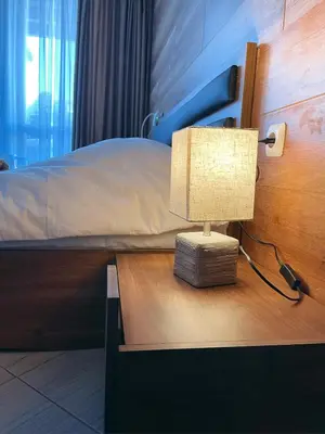 a lamp on a table next to a bed at B8 Luxury Studio Apartment in Green Life Bansko in Bansko