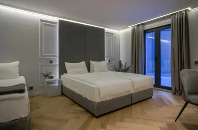 a bedroom with a large bed and a large window at Sentro Boutique Hotel in Sofia