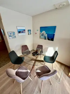 a room with four chairs and a glass table at Вила Динати in Perushtitsa