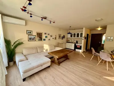 a living room with a white couch and a table at Вила Динати in Perushtitsa