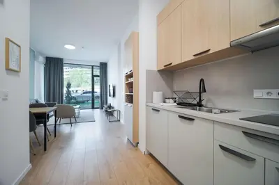 a kitchen with white cabinets and a dining room at Mycampus 1 bdrm, stay 4, free parking, garden, self check-in in Sofia