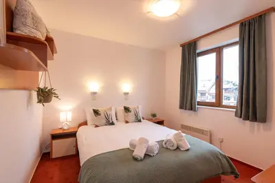 a bedroom with a bed with two towels on it at Mountain View Apartment with Balcony & Ski Access nearby - Serendipity in Bansko