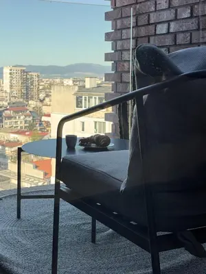 a chair and a table with a view of a city at Sofia Rooftop Red Apple in Sofia