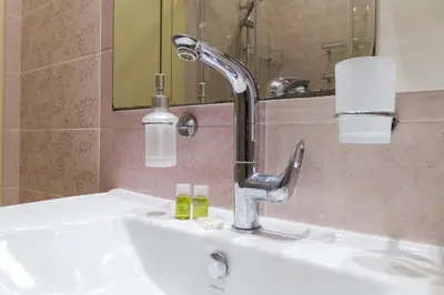 a bathroom sink with a faucet and a mirror at Riverside 2-Bedroom Apartment in Plovdiv