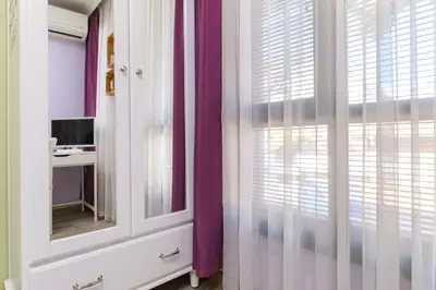 a room with a mirror and a window with purple curtains at Riverside 2-Bedroom Apartment in Plovdiv