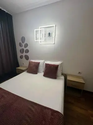 a bedroom with a white bed with two pillows at Grace Appartament in Plovdiv