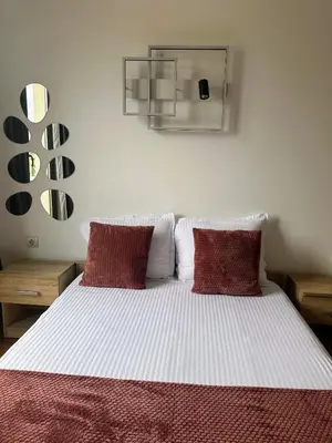 a bedroom with a bed with two red pillows at Grace Appartament in Plovdiv